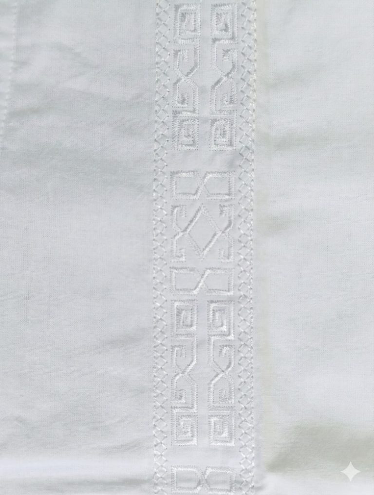 Descubre el equilibrio perfecto entre tradición y modernidad. Esta guayabera blanca destaca por sus impecables bordados verticales con patrones geométricos, que añaden una textura rica y un carácter distintivo a la prenda. ​Diseñada pensando en el clima cálido, su corte permite la circulación del aire, manteniéndote fresco durante bodas en la playa, cenas al atardecer o eventos corporativos al aire libre. Cuenta con dos bolsillos funcionales en la parte inferior que refuerzan su estilo utilitario y clásico. ​Estilo: Formal de playa / Casual elegante. ​Detalles: Botones nacarados y cuello estructurado. ​Ideal para: Bodas, bautizos y vacaciones de lujo.