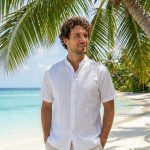 Elegancia caribeña atemporal. Esta guayabera combina la tradición con la máxima frescura. Confeccionada en un tejido ligero y transpirable, presenta los clásicos bordados verticales y alforzas que definen su estilo, junto con dos bolsillos funcionales en la parte inferior. La prenda perfecta para bodas en la playa, cenas al atardecer o para elevar tu estilo vacacional.